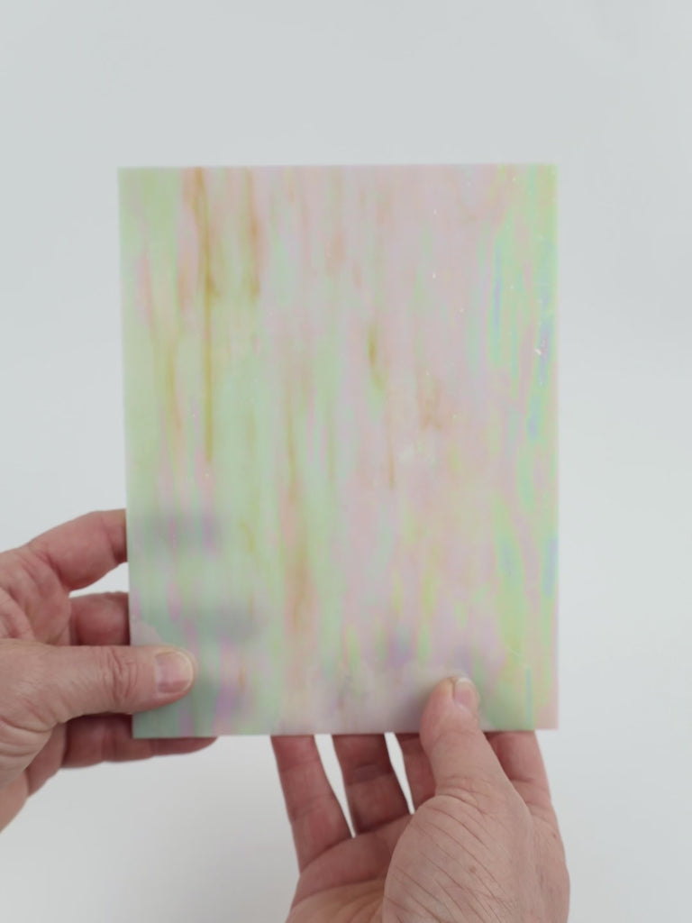 Video of the witched glass plate in beige translucent iridescent, 15x19cm, held up and tilted to show its pattern and transparency