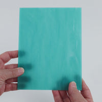 Video of the Pale Waterfall glass plate in translucent turquoise, 15x19cm, held up and tilted to show its pattern and transparency