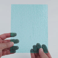 Video of the Aqua Gentle Waves glass plate in hammered transparent blue, 15x19cm, held up and tilted to show its pattern and transparency