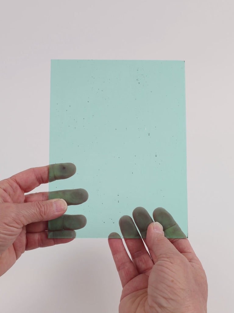 Video of the Pale Sea glass plate in transparent teal, 15x19cm, held up and tilted to show its pattern and transparency