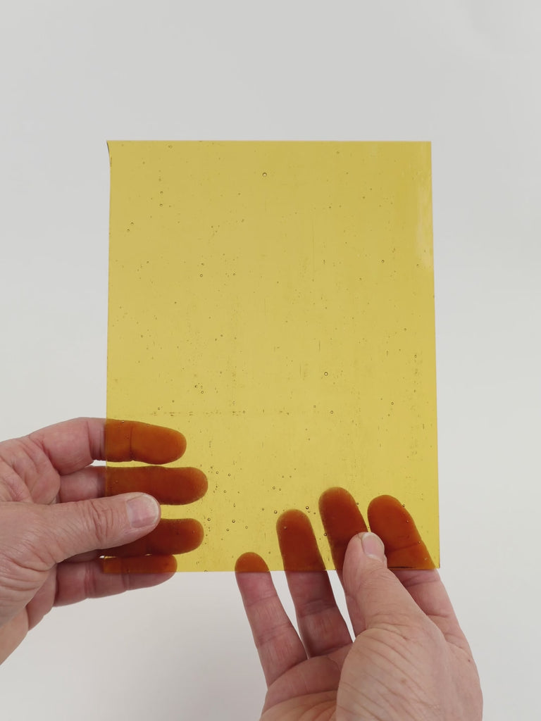 Video of the Amber glass plate in transparant amber, 15x19cm, held up and tilted to show its pattern and transparency
