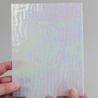 Video of the coconut pearl glass plate in white translucent iridescent, 15x19cm, held up and tilted to show its pattern and transparency
