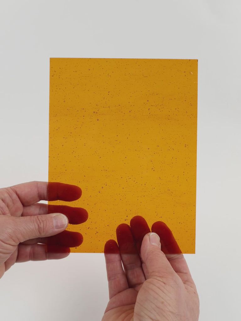 Video of the Deep Amber glass plate in transparant amber, 15x19cm, held up and tilted to show its pattern and transparency