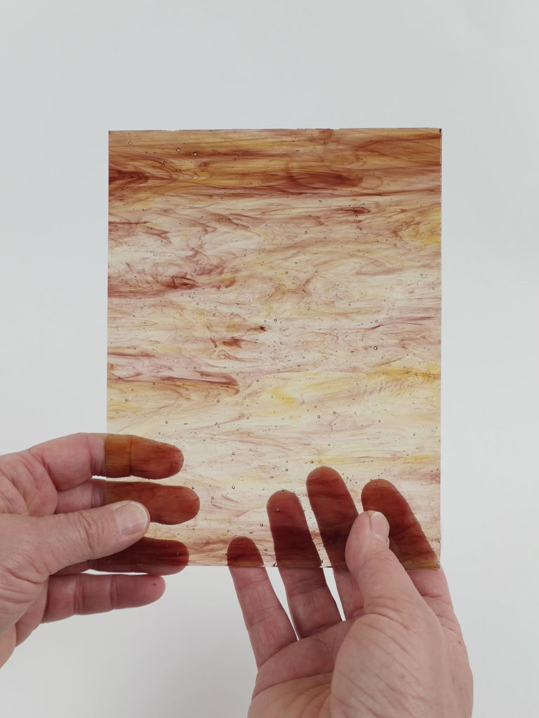 Video of the brown wispy glass plate in brown transparant, 15x19cm, held up and tilted to show its pattern and transparency