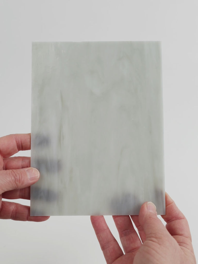 Video of the plate pewter glass plate in grey translucent marbled, 15x19cm, held up and tilted to show its pattern and transparency