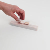 Video of Marble Bars XL Rosa Porta in opaque pink natural marble, 1–20 cm long and 8 mm thick, picked up by hand and turned to show their length, colour and natural veining