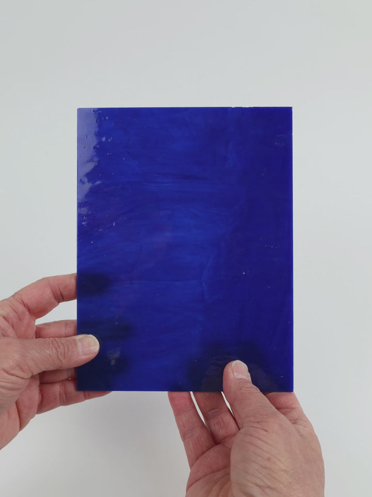 Video of the Cobalt Wispy glass plate in translucent blue, 15x19cm, held up and tilted to show its pattern and transparency
