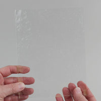 Video of the clear seedy texture glass plate in white transparant, 15x19cm, held up and tilted to show its pattern and transparency