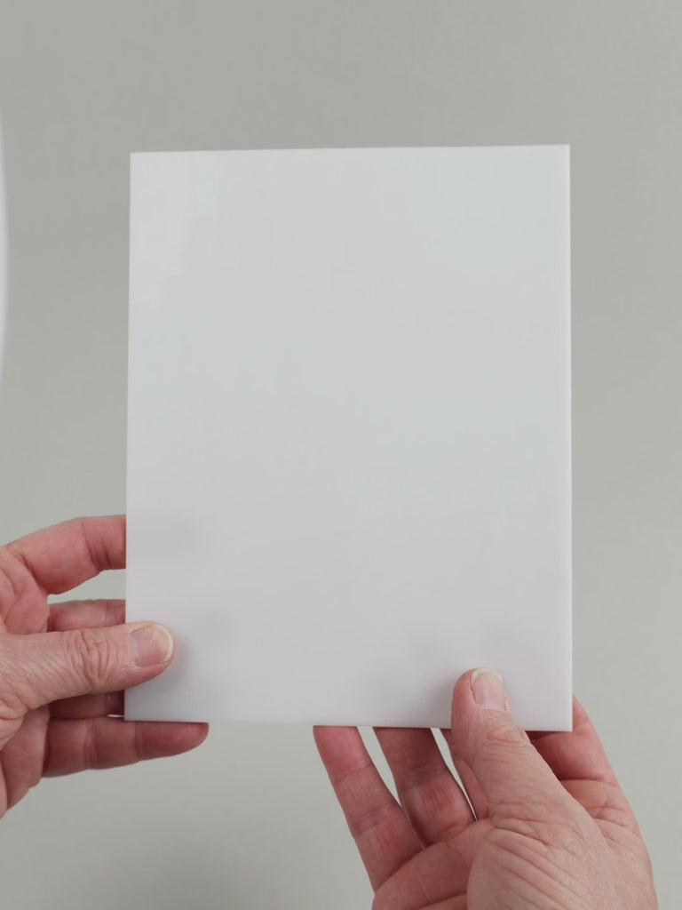 Video of the pure white glass plate in white semi-transparant, 15x19cm, held up and tilted to show its pattern and transparency